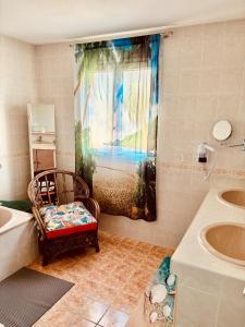 a bathroom with a window with a sink and a chair at Superbe Villa avec piscine - vue mer - Presqu'Île de Giens - 5 étoiles in Hyères