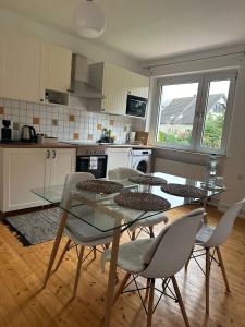 a kitchen with a glass table and chairs in it at Top Ferienwohnung 55qm, Netflix, Prime in Bochum