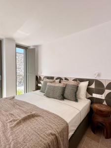 a bedroom with a large bed with white sheets and pillows at Egeo Paros in Kampos Paros