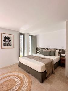 a bedroom with a large bed and a rug at Egeo Paros in Kampos Paros