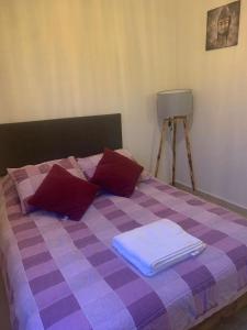 a purple and purple checkered bed with towels on it at Cómodo Departamento con Ubicación privilegiada 