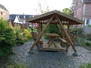 a wooden gazebo with a picnic table in a garden at Maisonnette de Gadag in Forges-les-Eaux