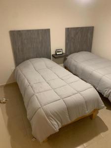 two beds sitting next to each other in a bedroom at Cómodo Departamento con Ubicación privilegiada 