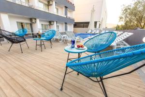 un patio con sillas azules y mesas en un edificio en HOME HOTEL SCANDINAVIA en Ulcinj