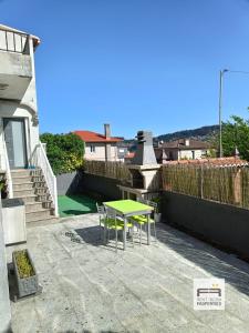 una mesa verde y sillas en un patio en Amplia casa de 9 hab, Cabral., en Vigo