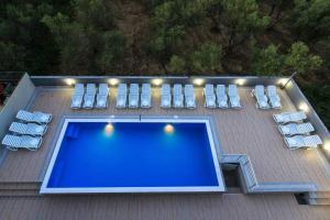 una piscina en una terraza con tumbonas en HOME HOTEL SCANDINAVIA en Ulcinj