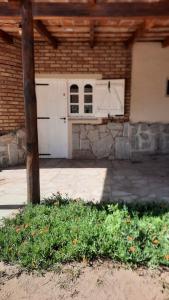 a garage with a white door and a brick building at Casita en el monte in San Marcos Sierras