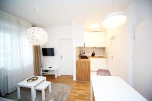 a white apartment with a kitchen and a living room at Apartment Fala - self check-in 0-24, fast wi fi, city center in Zagreb