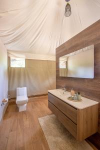 a bathroom with a sink and a toilet and a mirror at Mopani Safari Lodge in Mfuwe