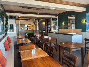 un restaurante con mesas y sillas de madera y un bar en The Yacht Inn, en Penzance