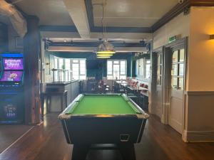 uma sala de bilhar com uma mesa de bilhar e um bar em The Yacht Inn em Penzance