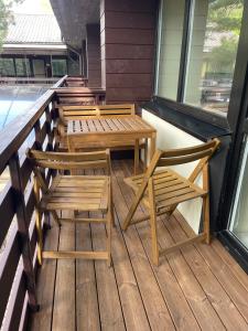 a row of wooden tables and chairs on a porch at Nidos kempingas in Nida