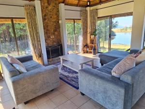 a living room with two couches and a fireplace at Lakeview Cottage, Curry's Post - SOLAR POWERED in Howick