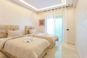 - une chambre avec 2 lits et une fenêtre dans l'établissement Luxury Odyssey - Marrakech Centre, à Marrakech