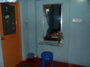 
a small bathroom with a blue wall and blue curtains at Thisal Guest House in Polonnaruwa
