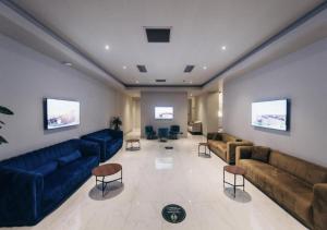 P A N O R A M A A P R T H T E L ORBI WiTH SEA VIEW في باتومي: غرفة معيشة كبيرة مع أرائك وكراسي زرقاء