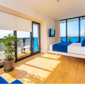 een slaapkamer met een bed en een groot raam bij P A N O R A M A A P R T H T E L ORBI WiTH SEA VIEW in Batoemi