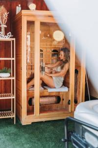 una mujer está sentada en un armario de madera en Alina Apartman, en Neszmély