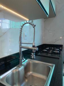 a kitchen sink with a faucet in a kitchen at Flat luxo Capitólio in Capitólio