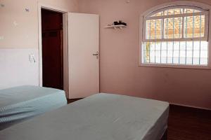 a bedroom with two beds and a window at Villa Brisa Azul in Atibaia +30 photos
