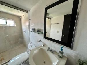 W łazience znajduje się umywalka, toaleta i lustro. w obiekcie Sirenas w Acapulco