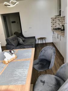 uma sala de estar com um sofá, uma mesa e cadeiras em Light Apartments em Chernigov