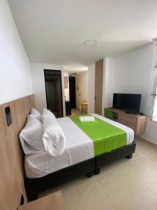 Caliview Apartahotel في كالي: غرفة نوم بسرير كبير وتلفزيون