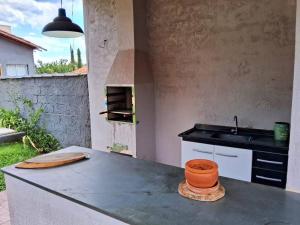 a kitchen with a counter with a sink and a stove at Villa Brisa Azul in Atibaia