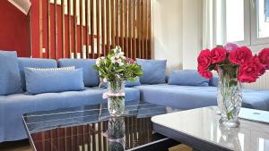 - deux vases avec des fleurs sur une table dans le salon dans l'établissement Alivia Garden, à Paliouri
