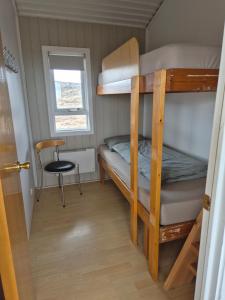 a small room with a bunk bed and a chair at Eaglerock guesthouse 2 in Kirkjubæjarklaustur