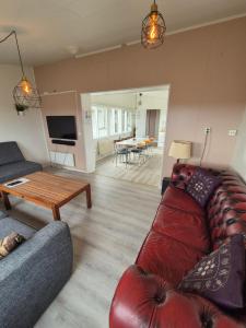 ein Wohnzimmer mit einem roten Sofa und einem Tisch in der Unterkunft Eaglerock guesthouse 2 in Kirkjubæjarklaustur