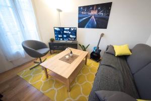 a living room with a couch and a table at Contemporary, view of La Défense, all comfort in Puteaux +4 photos