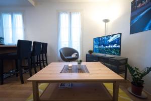 a living room with a table and a television at Contemporary, view of La Défense, all comfort in Puteaux