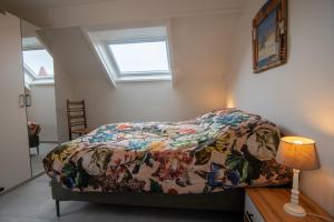 a bedroom with a bed with a comforter on it at Appartementen Zee Domburg in Domburg