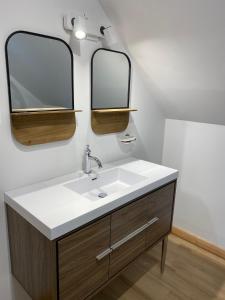 un baño con lavabo y dos espejos en Chalet Mont Édouard de 4 unités, en L'Anse-Saint-Jean