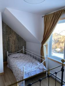 un dormitorio con una cama y una ventana en Chalet Mont Édouard de 4 unités, en L'Anse-Saint-Jean