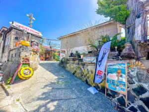 a building with a surfboard on the side of a street at OKESYOU - Vacation STAY 60189v in Niijimamura