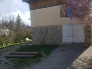 un bâtiment avec une porte blanche et un garage dans l'établissement L Étoile du Verdon, à Saint-André-les-Alpes