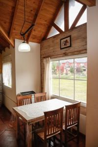a dining room with a table and chairs and a window at Patagonia Hostel in El Chalten