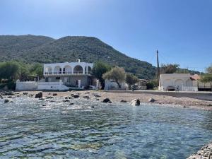 een huis op een strand naast een waterlichaam bij Komi Beach Condo with 3 Bedrooms in Chios