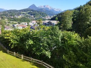 uma aldeia nas montanhas com uma cerca e árvores em Ferienwohnungen Arnold Berchtesgaden em Berchtesgaden