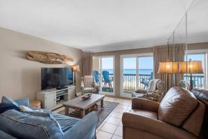 a living room with a couch and a tv at Pinnacle Port C1-302 in Carillon Beach