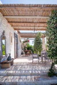 een patio met 2 banken en een houten plafond bij Masseria Verbena suites in Macchia di Monte