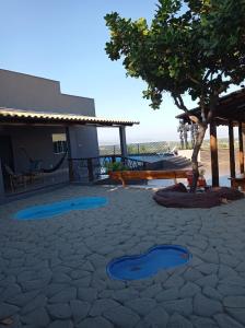 twee blauwe frisbees op een patio met een boom bij Rancho Léo Artes in Três Marias