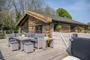 un patio con sillas, una mesa y una casa en Tesseyman Lodge, en Bubwith