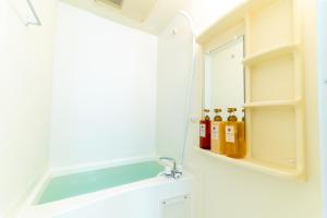 ein Badezimmer mit einem Waschbecken, einem Spiegel und einigen Flaschen in der Unterkunft VIDA Hakata 803 - Vacation STAY 48060v in Sumiyoshi