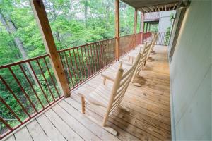 Un porche con barandillas de madera en una casa. en Sasquatch Lode CD Sleeps 22, en Gatlinburg