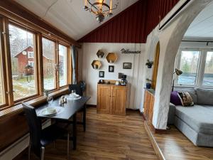 ein Wohnzimmer mit einem Tisch und einem Sofa in der Unterkunft Rustic Haven Bed and Breakfast near Klarälvsbanan and Swimming area in Munkfors