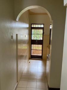 an empty hallway with a door and a window at Queens apartments in Entebbe