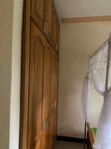 a bedroom with wooden cabinets and a bed in it at Queens apartments in Entebbe